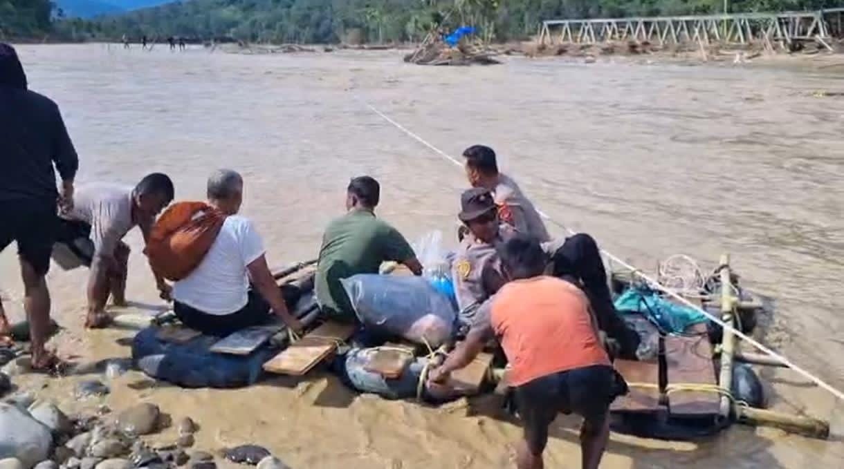 Personel Polres Gayo Lues Salurkan Sembako dengan Menyeberangi Sungai  Menggunakan Perahu Ban di Desa Pasir - WASPADA24.COM