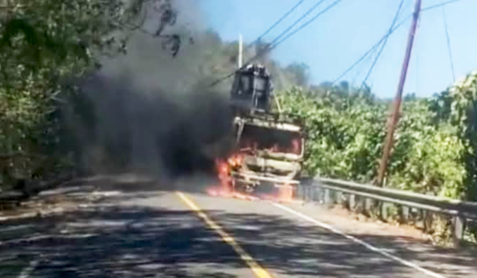 ‎Truk tronton bermuatan alat berat jenis Bomag hangus terbakar di ruas Jalan Trans Desa Marinsouw, Kecamatan Likupang Timur. (Dok. Istimewa)